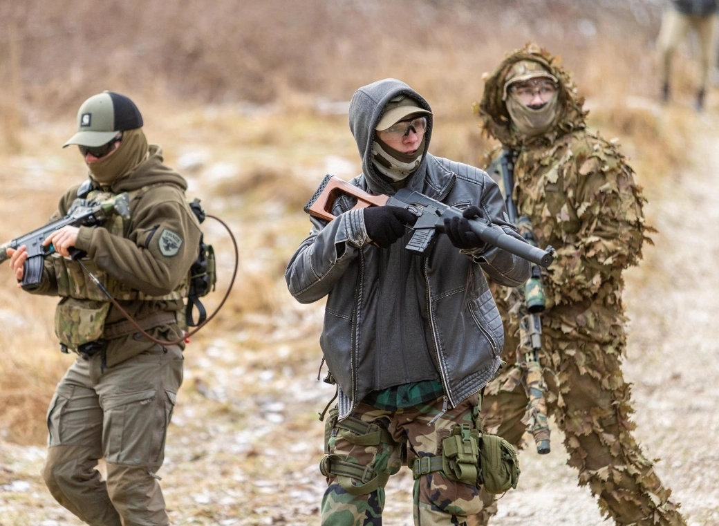 Airsoft players in field tactical gear advancing through Estonian forest